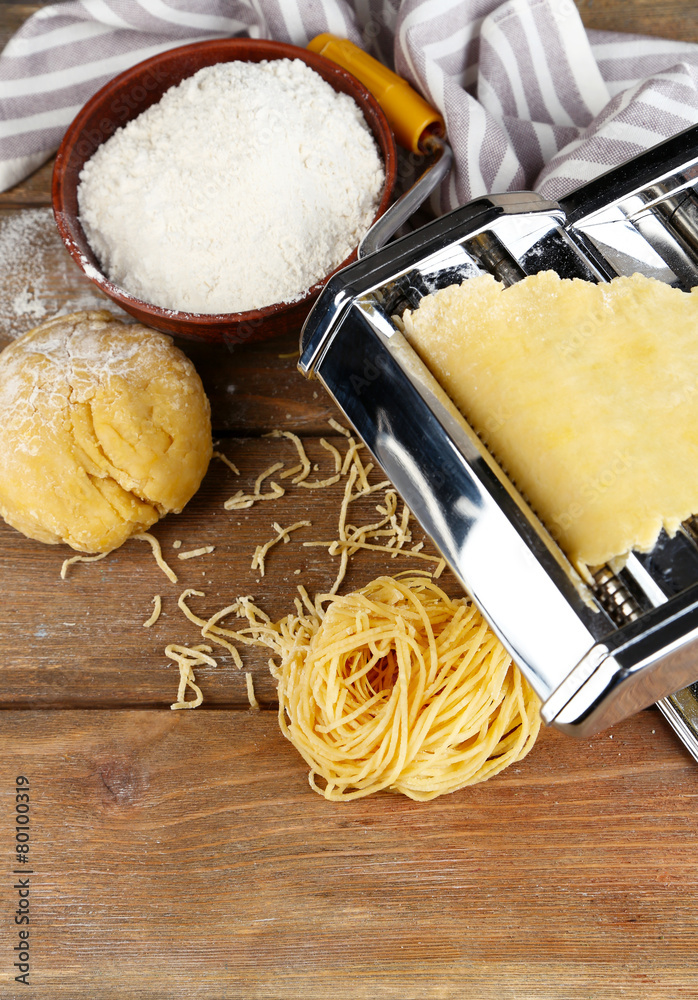 Making vermicelli with pasta machine on wooden background