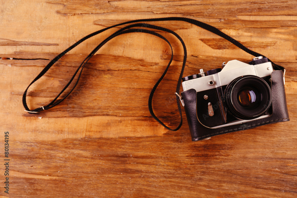 Retro photo camera on wooden background