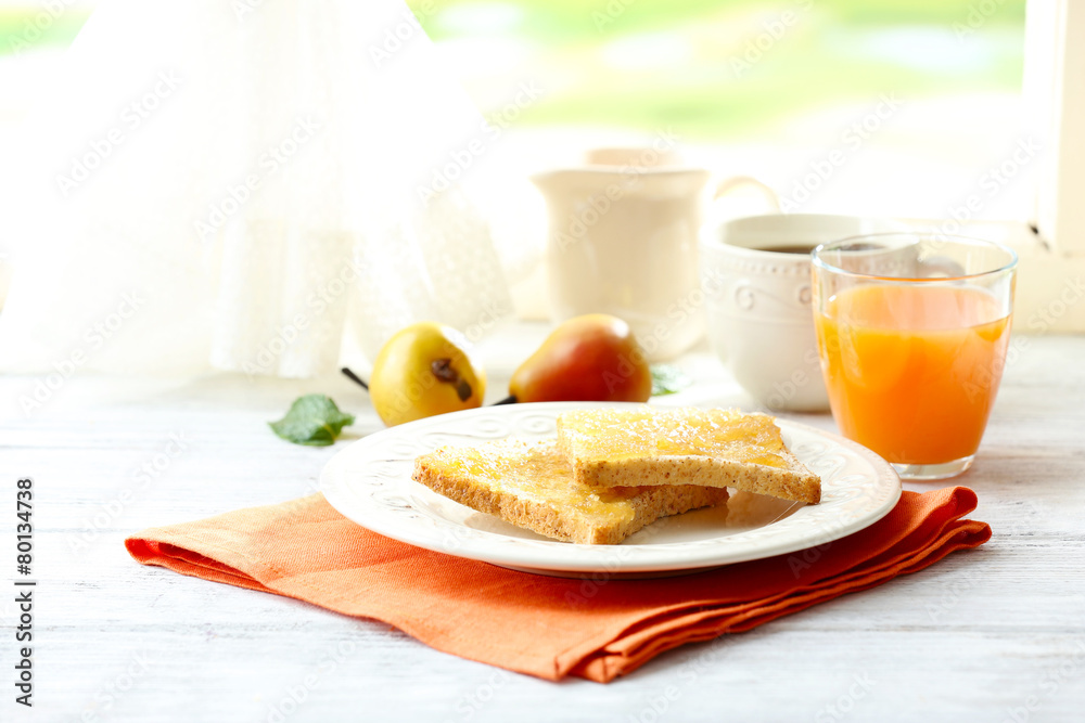 Toasts with honey on plate with cup of tea on bright background
