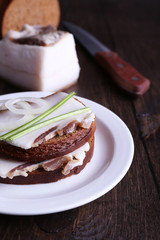 Wall Mural - Sandwiches with lard on plate on wooden background