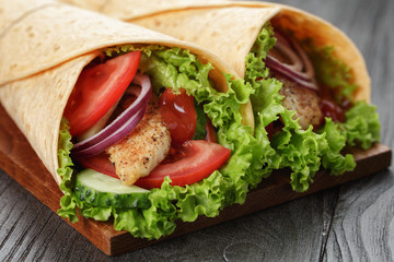 pair of fresh juicy tortilla wraps with chicken and vegetables