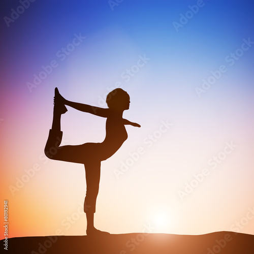 Fototapeta Žena v józe pozice tanečníka meditovat při západu slunce. Zen
