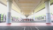 Several People Play Basketball At Playground Under Overpass