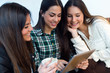 © nenetus - Three young woman using digital tablet at cafe shop.