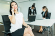 © NDABCREATIVITY - Businesswomen in an office working and calling by phone