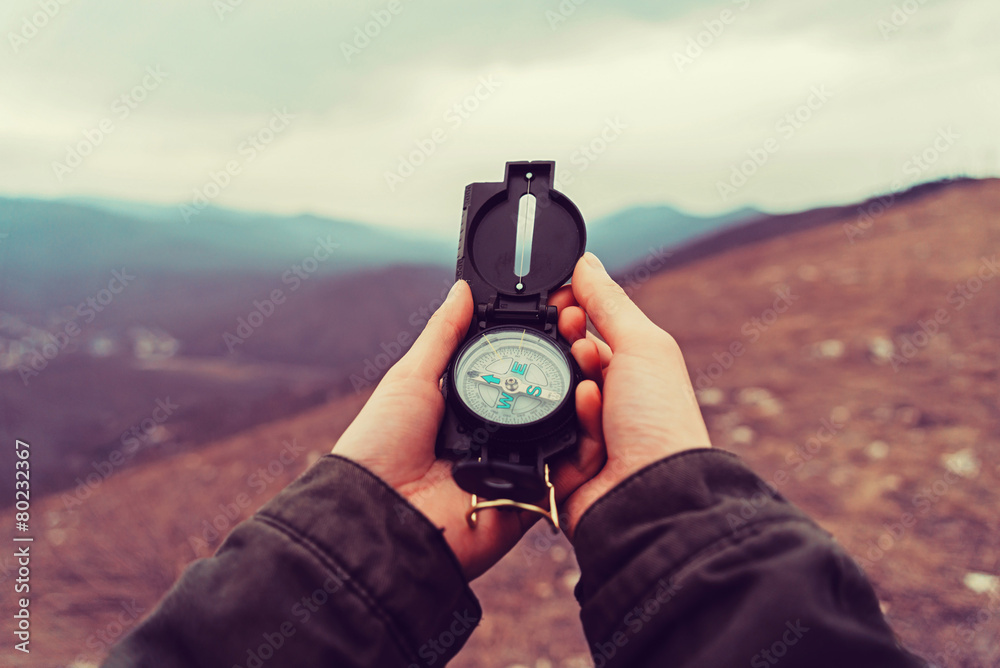 Hiker woman with a compass in the mountains - obrazy, fototapety, plakaty 