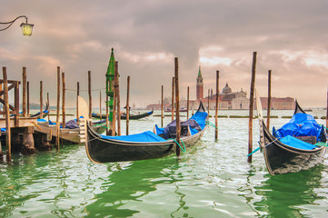  Gondolas docked to the poles on the Grand Canal in Venice.
