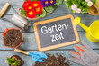 Tafel auf Pflanztisch mit Gartenutensilien - Gartenzeit