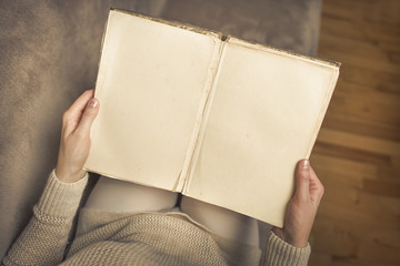 Girl with book in hand at home.