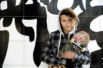 Wall Mural - portrait of young guy  with skate and rasta hair