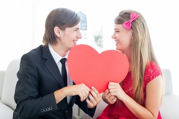 Poster - Cute geeky couple smiling and holding heart