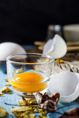 Still life broken white eggs and egg yolk on a wooden rustic bac