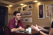 © undrey - Friends man young woman are having a conversation in the cafe