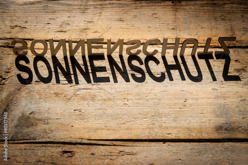 Buchstaben aus Holz bilden das Wort Sonnenschutz StockFoto Adobe Stock