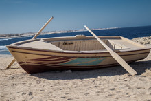 Wooden Boat With Two Oars On Beach