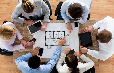 business team with blueprint and gadgets