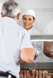 © Tyler Olson - Female Butcher Looking At Customer