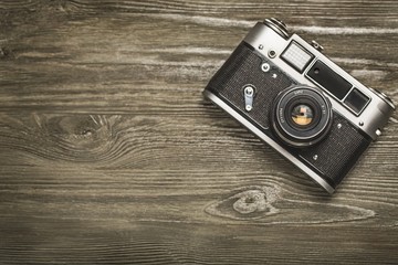 Wall Mural - Camera. vintage old camera on brown wooden background. room for