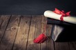 © BillionPhotos.com - Academic. A diploma scroll tied with red ribbon, resting on a