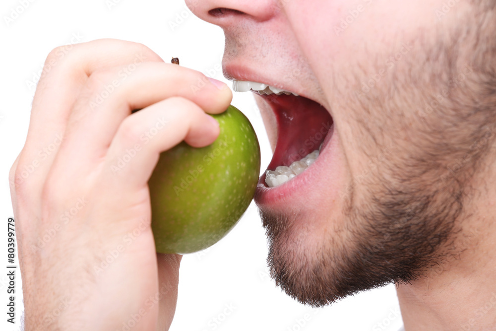 Man biting fresh green apple with healthy teeth isolated