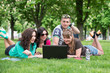 © lexmomot - Group of Teenage Students at Park with Computer and Books