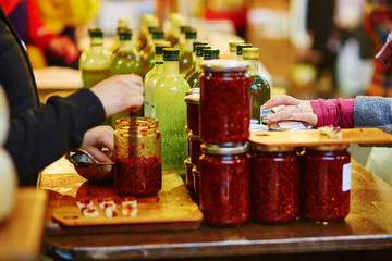 Wall Mural - Woman degusting olive oil and sauces on market