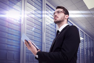 Poster - Composite image of businessman looking away while using tablet