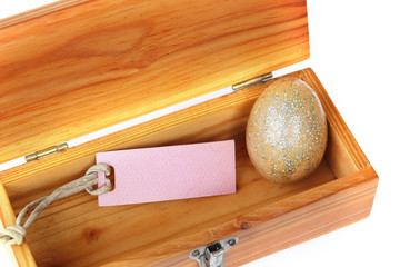 Wall Mural - Golden easter egg in wood box on white.