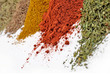Heaps of different dry spices on a white