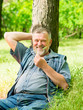 © kostyha - old man resting under a tree in the park