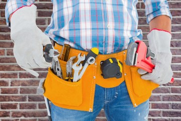 Poster - Composite image of midsection of handyman holding hand tools