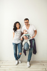 Hipster father, mother holding cute baby boy over white backgrou