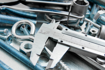 Caliper and tools on the scratched metal background.