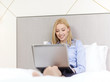 © Syda Productions - happy businesswoman with laptop in hotel room