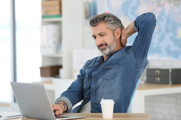 Canvas Print - Mature man relaxing in front of laptop in class