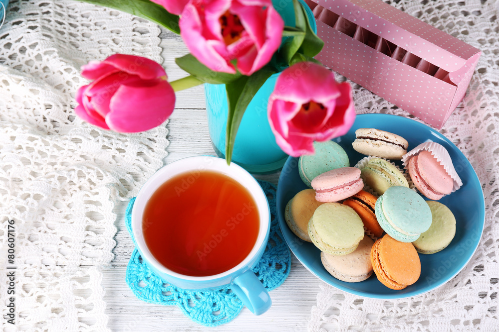 Composition of spring flowers, tea and cookies on table