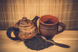 old clay teapot and black leaf tea