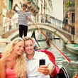 Selfie couple using smartphone in Venice gondola
