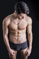 Wall Mural - Handsome, fit young man in underwear isolated on black