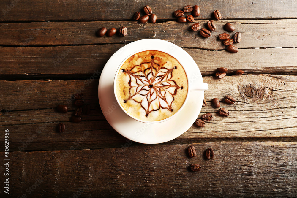 Cup of latte on wooden table, top view