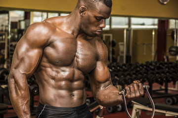 hunky muscular black bodybuilder working out in gym