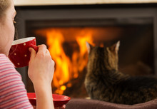 Girl With Drink And Cat Relaxing By Fireplace