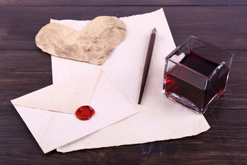 Wall Mural - Envelope with pen and ink on wooden background