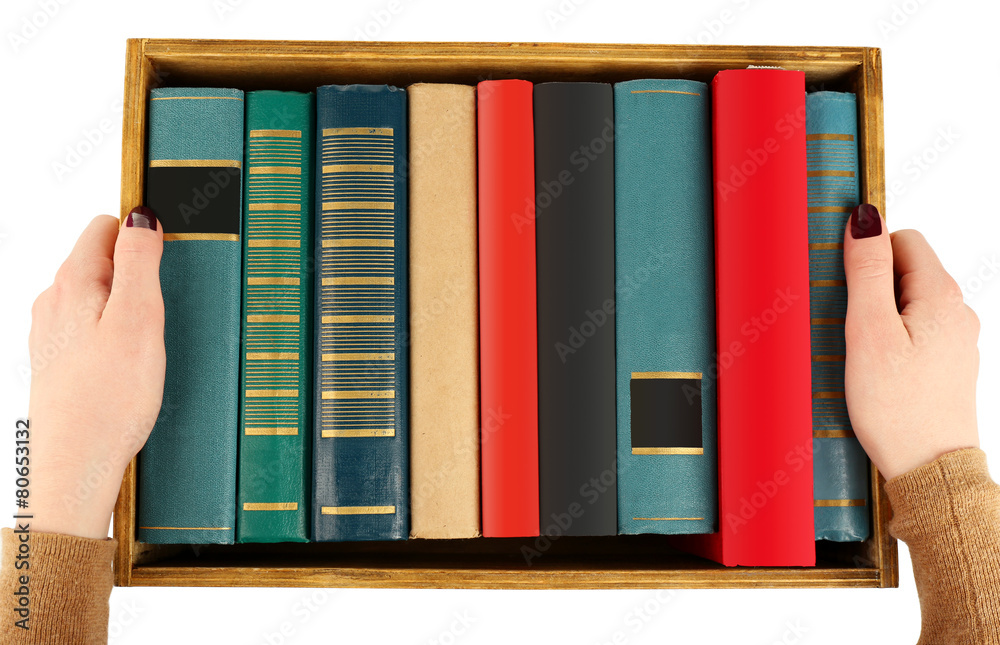 Books in wooden box in female hands, top view
