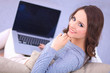 © shefkate - Happy pretty woman using laptop sitting on  sofa