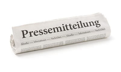 Zeitungsrolle mit der Überschrift Pressemitteilung