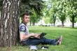 © lexmomot - Man reading book in park, sitting under a tree