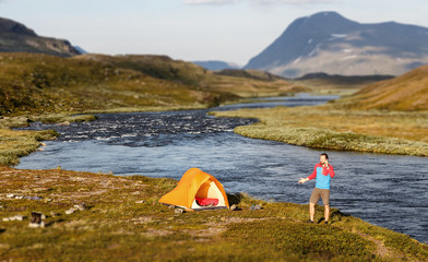 Wall Mural - hiker and handy in front of a tent