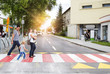 Young family with two boys in the city walking on a crosswalk