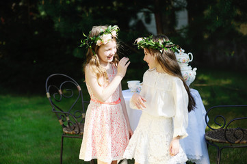 Two adorable kid girls with flower wrearth